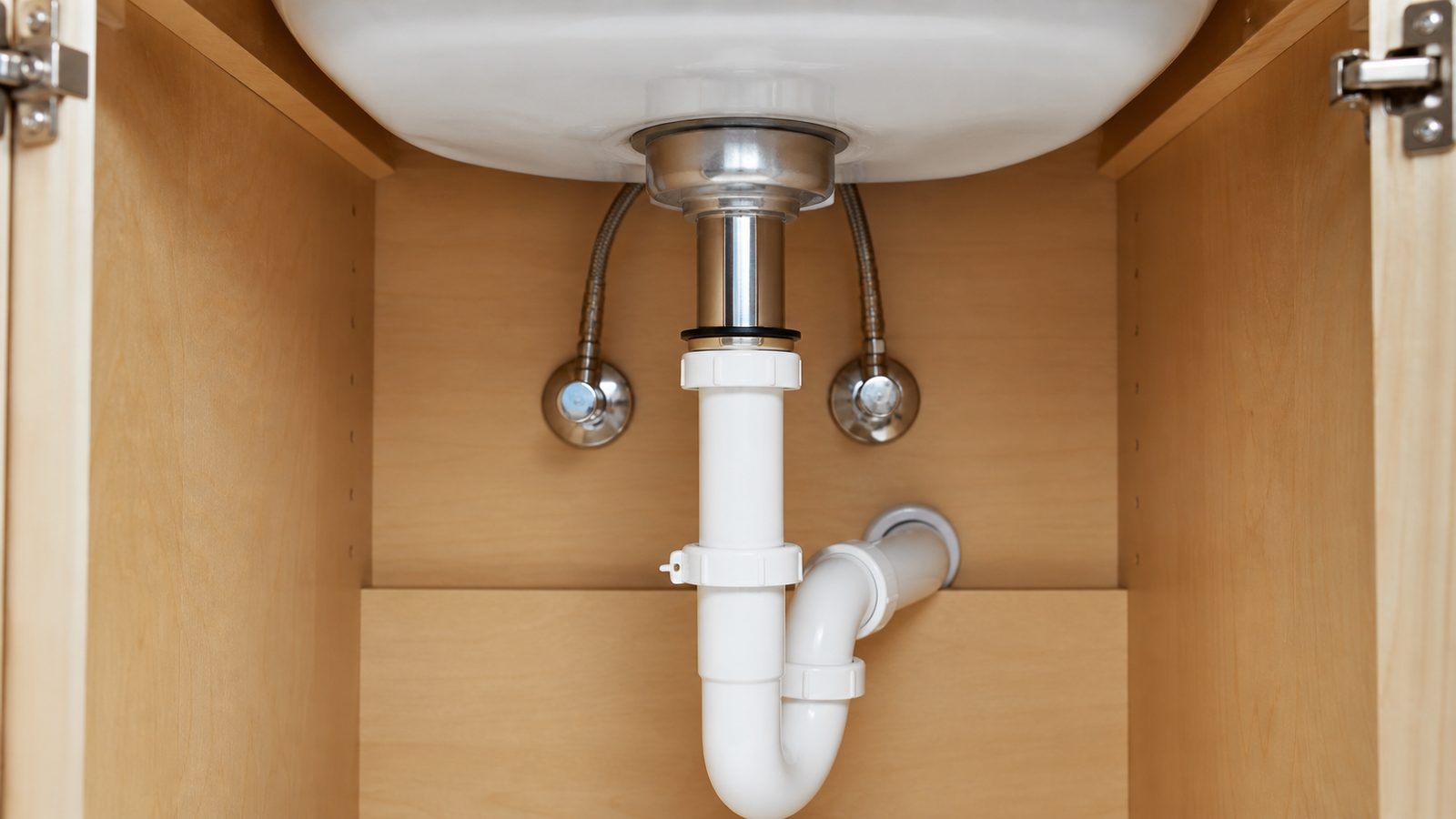 Bathroom sink drain body and pop-up linkage inside a vanity cabinet