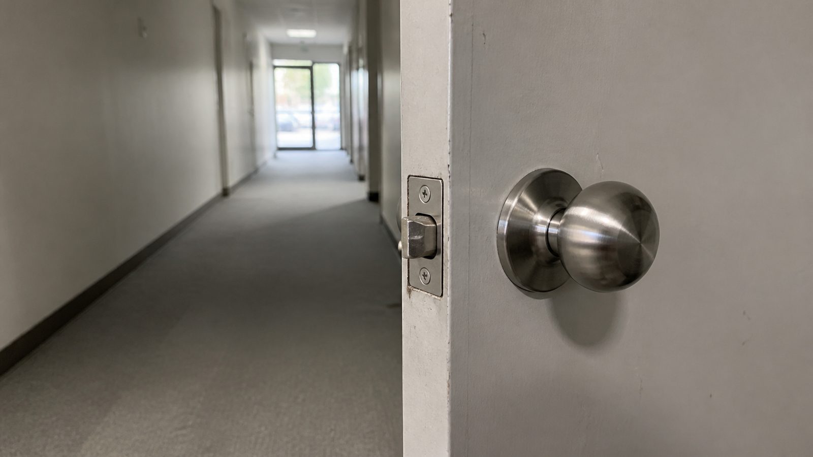 Round commercial door knob along an otherwise clear interior corridor