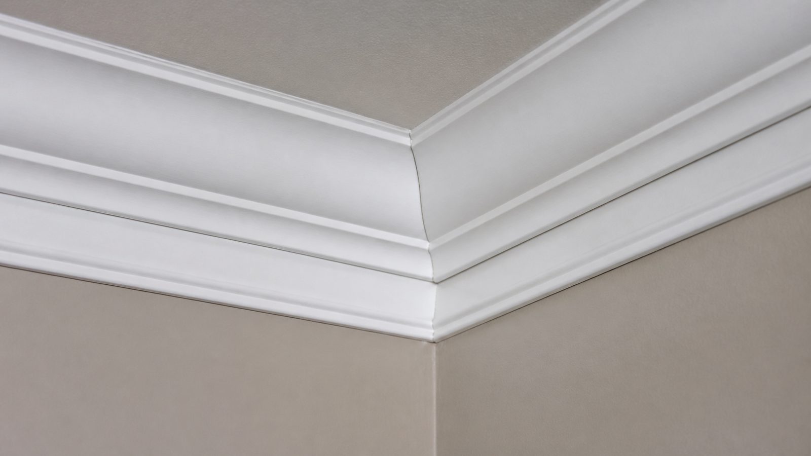 Primed crown molding meeting at a tight inside-corner miter