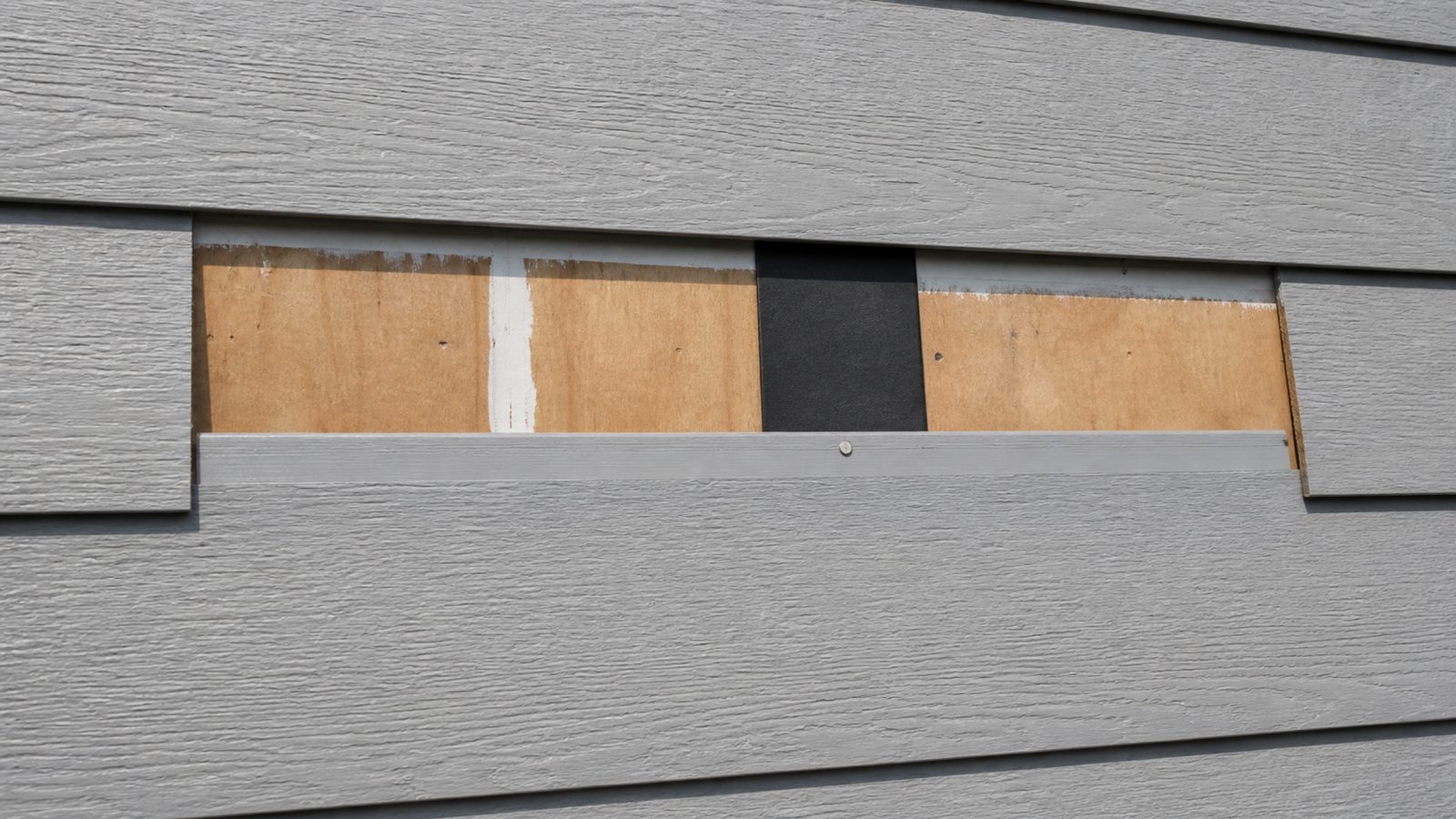 New fiber cement plank aligned over joint flashing with a flush galvanized fastener