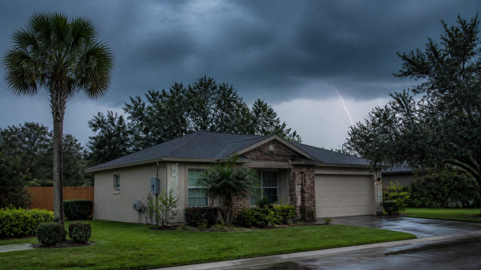 Florida summer storm clouds beyond a residential roofline and palm trees