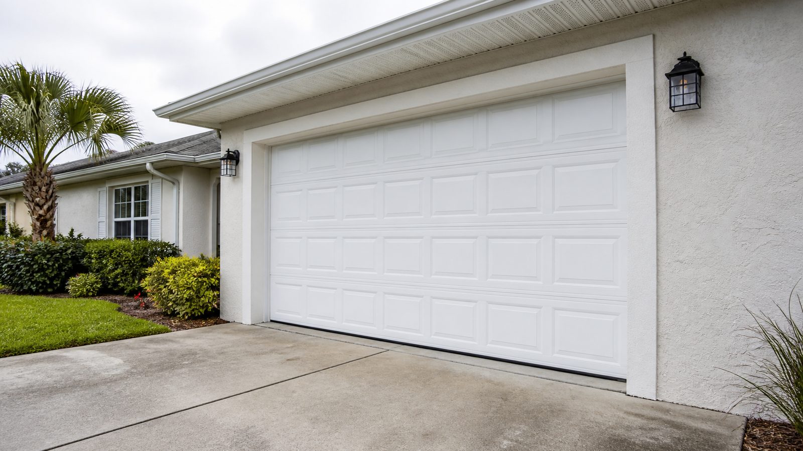 White sectional garage door on a modest Florida home with driveway context