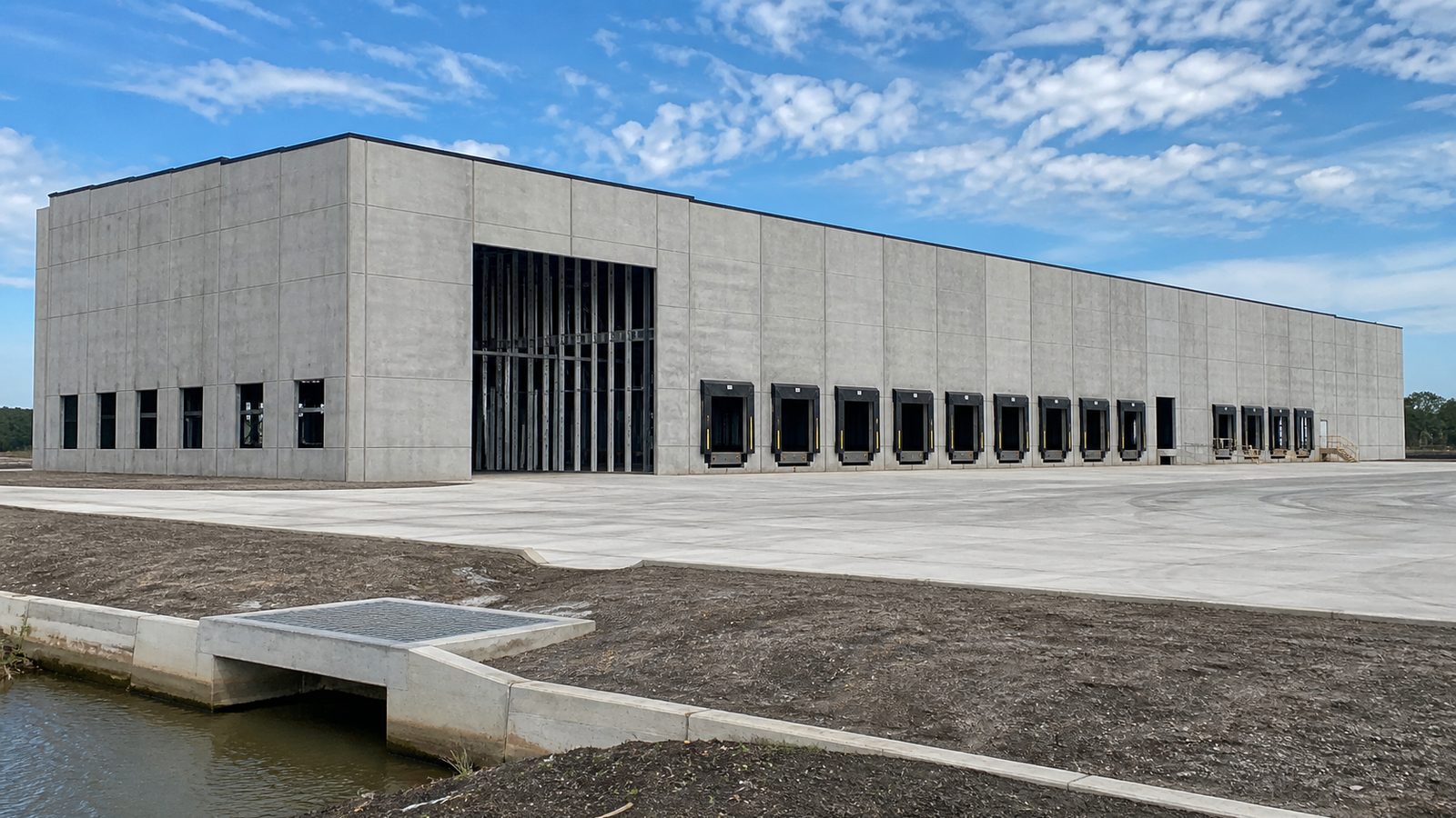 Empty Florida warehouse loading court with dock doors and drainage inlet