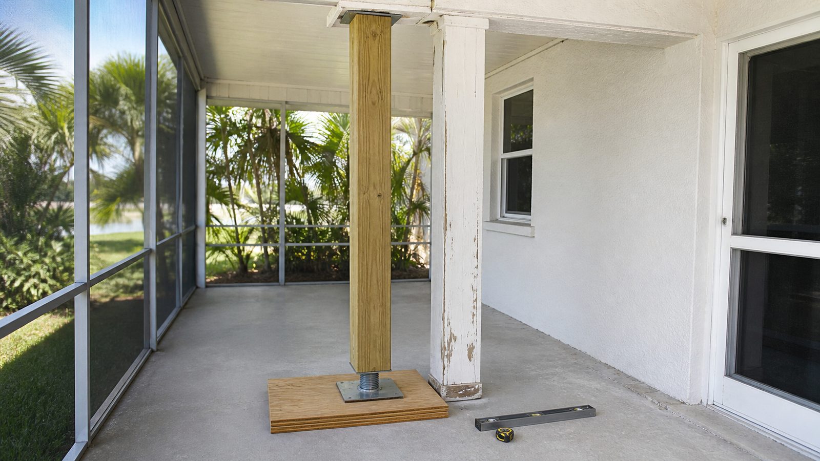 Timber shore and compact screw jack supporting a porch header beside a damaged column