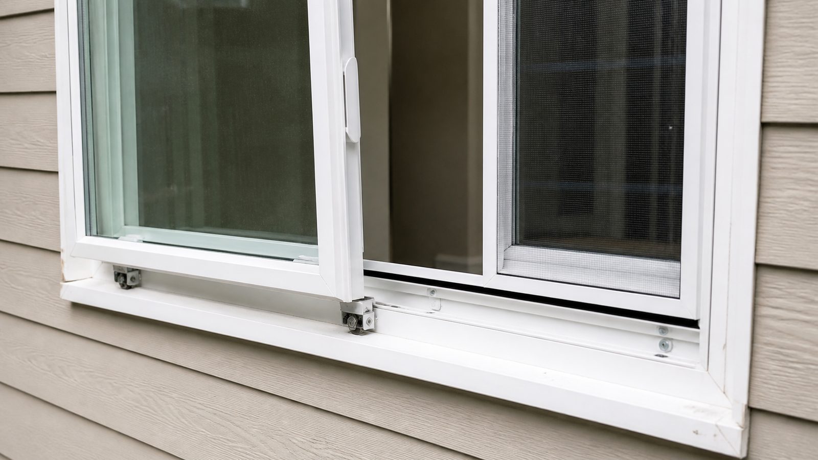 Horizontal sliding window with sash raised from the track and rollers visible