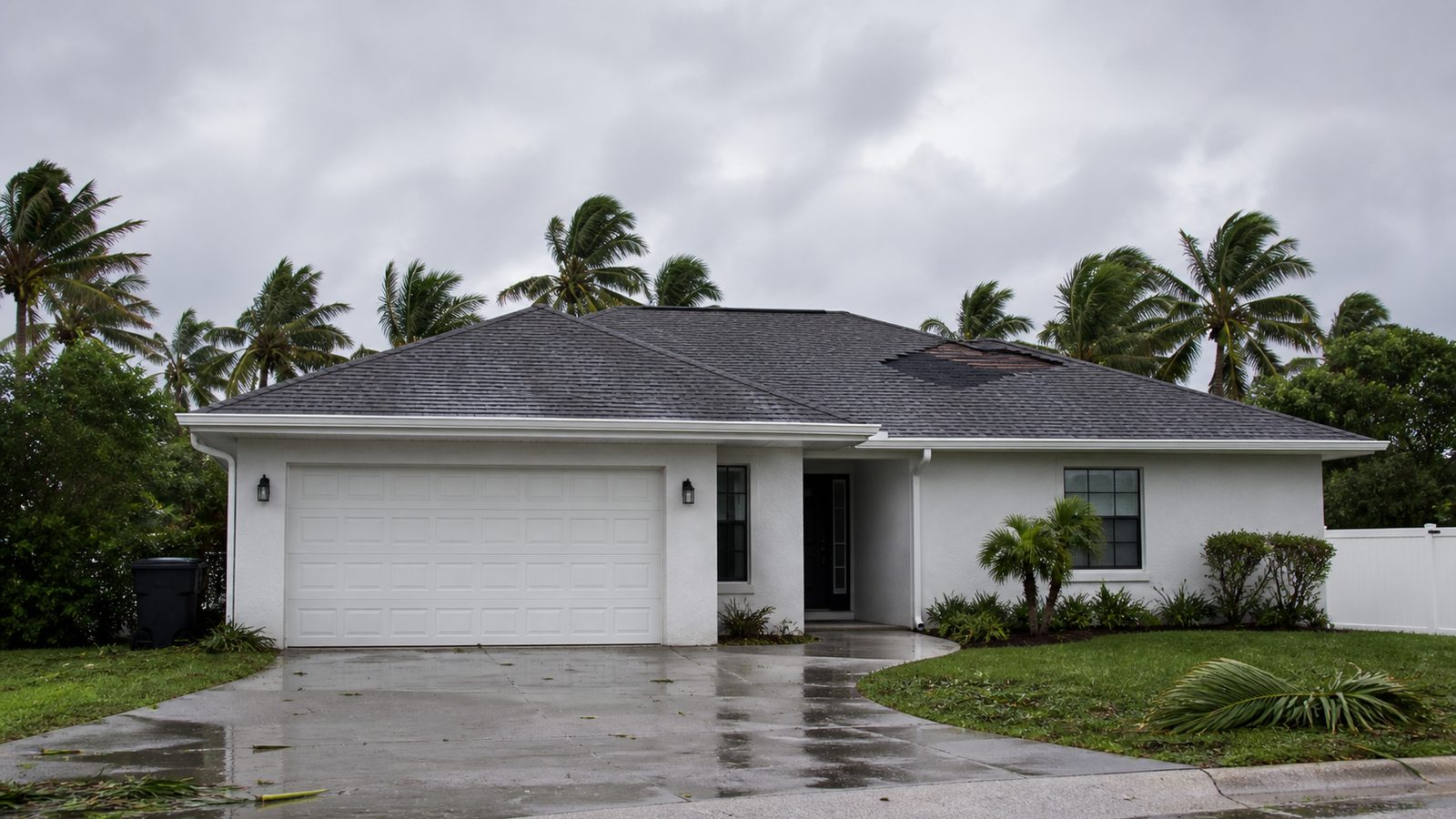 Florida hip roof with a localized patch of wind-missing shingles after a storm